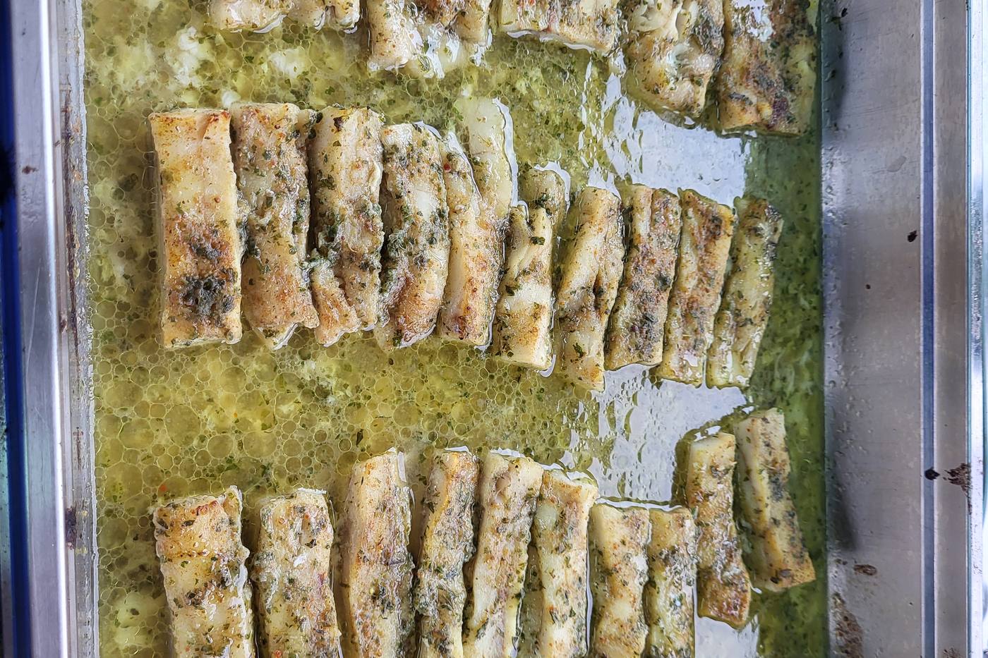 Rybí porce v bylinkové omáčce v gastronádobě, připravené k expedici